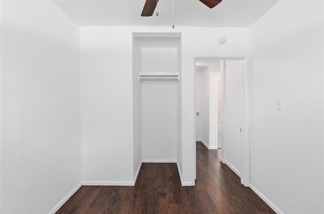unfurnished bedroom featuring a closet, a ceiling fan, baseboards, and dark wood-style floors