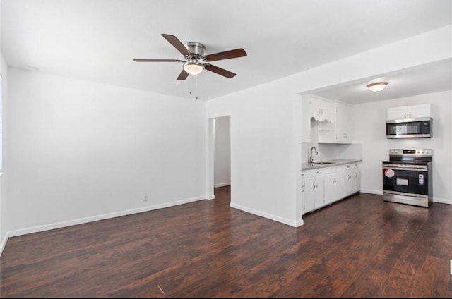 unfurnished living room featuring a ceiling fan, baseboards, dark wood finished floors, and a sink