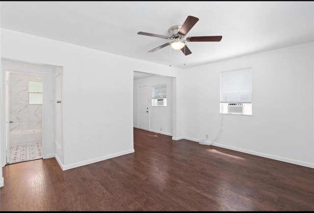spare room with wood finished floors, a ceiling fan, baseboards, and cooling unit