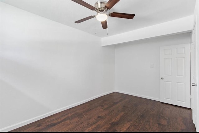 unfurnished room featuring baseboards, dark wood finished floors, and ceiling fan