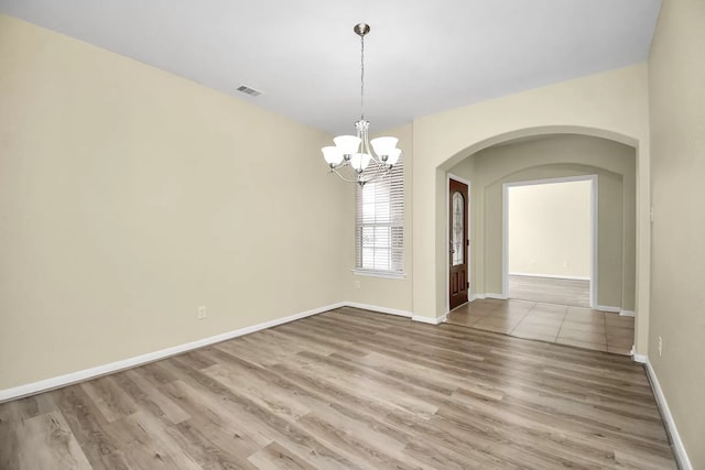 6315 Bain Dr, Missouri City, TX 77459 - unfurnished dining area featuring visible vents, wood finished floors, baseboards, a chandelier, and arched walkways