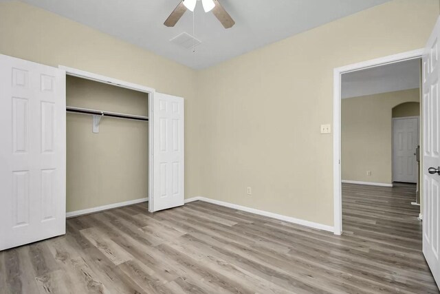 6315 Bain Dr, Missouri City, TX 77459 - unfurnished bedroom featuring arched walkways, baseboards, a closet, and wood finished floors