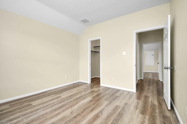 6315 Bain Dr, Missouri City, TX 77459 - unfurnished bedroom with visible vents, baseboards, a spacious closet, light wood finished floors, and vaulted ceiling
