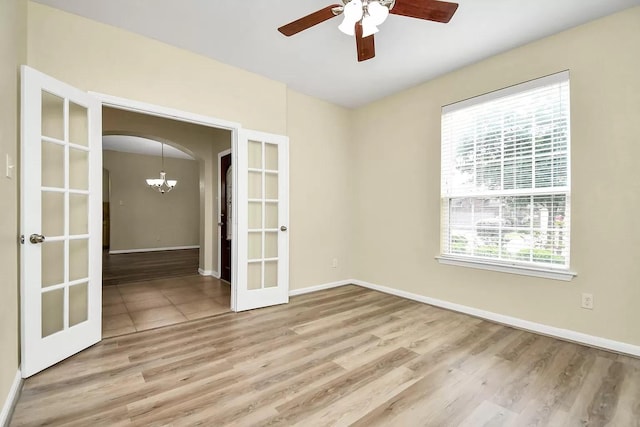 6315 Bain Dr, Missouri City, TX 77459 - empty room with plenty of natural light, french doors, ceiling fan with notable chandelier, and wood finished floors