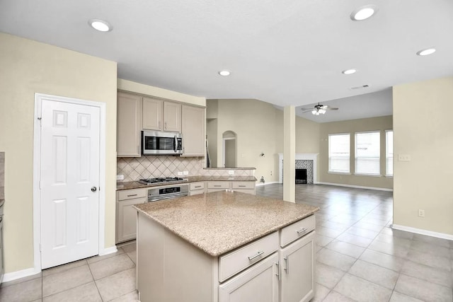 6315 Bain Dr, Missouri City, TX 77459 - kitchen with light tile patterned flooring, ceiling fan, appliances with stainless steel finishes, a center island, and tasteful backsplash
