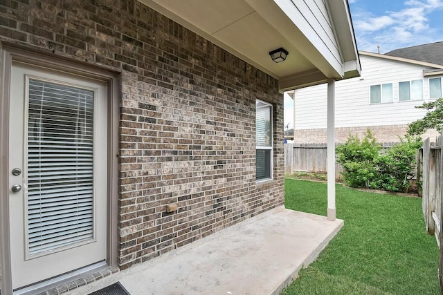 6315 Bain Dr, Missouri City, TX 77459 - view of exterior entry featuring brick siding, a patio area, fence, and a yard
