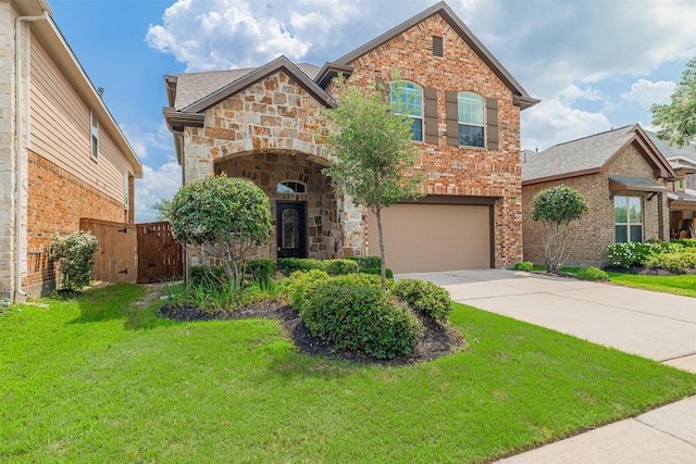 view of front of property with stone siding, a garage, brick siding, a front yard, and driveway