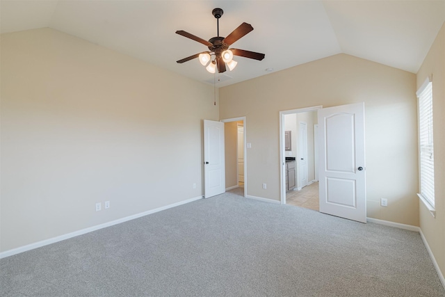 unfurnished bedroom with multiple windows, light carpet, and lofted ceiling