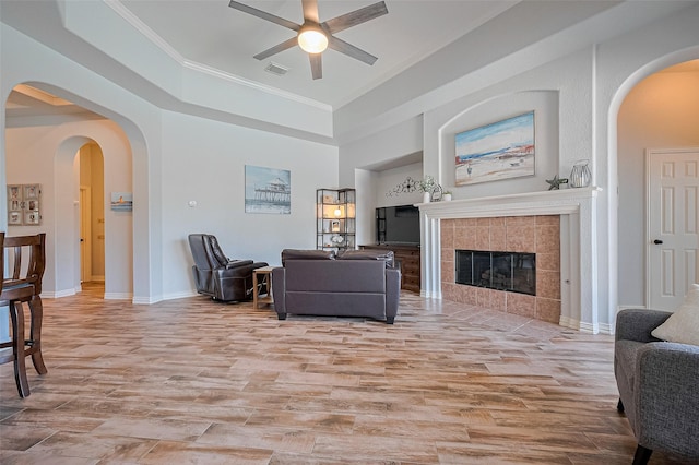26210 Seminole Hill Ln, Katy, TX 77494 - living area with light wood finished floors, ceiling fan, ornamental molding, baseboards, and a tile fireplace