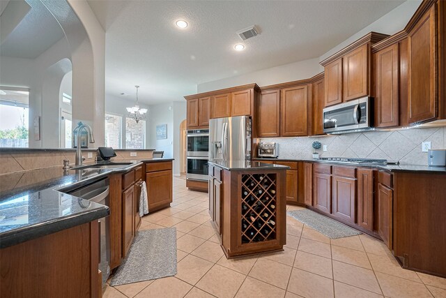 26210 Seminole Hill Ln, Katy, TX 77494 - kitchen featuring stainless steel appliances, a sink, a center island, backsplash, and a chandelier