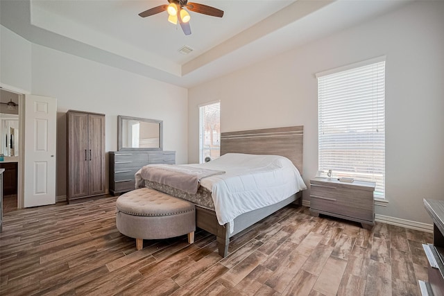 26210 Seminole Hill Ln, Katy, TX 77494 - bedroom featuring wood finished floors, a tray ceiling, a ceiling fan, and baseboards