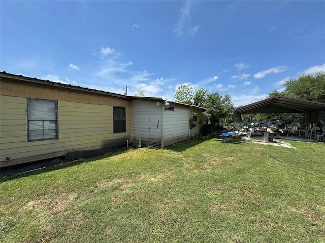 exterior space with a lawn, a detached carport, and a patio area