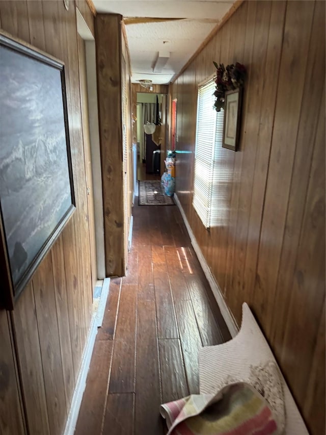 corridor with wooden walls and dark wood-style floors