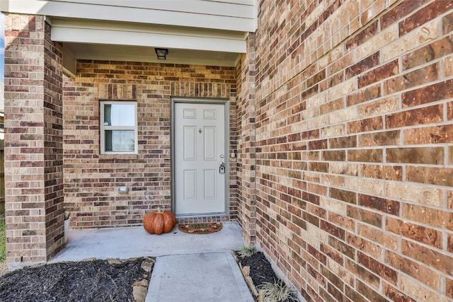 entrance to property featuring brick siding