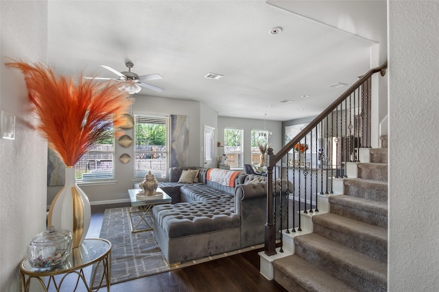 living area with ceiling fan, visible vents, wood finished floors, stairway, and baseboards
