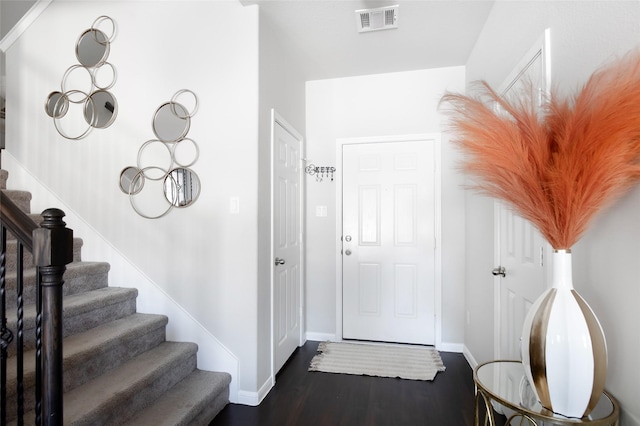 entrance foyer featuring stairs, baseboards, visible vents, and wood finished floors
