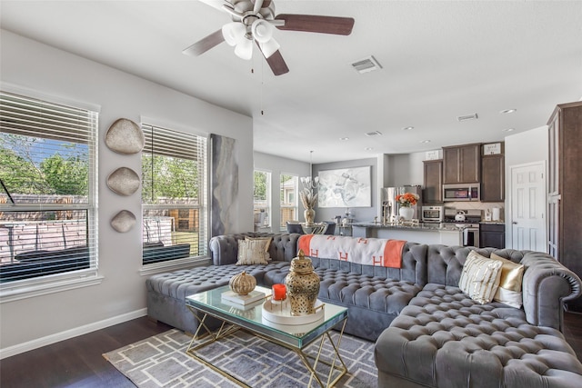 living area featuring baseboards, a ceiling fan, dark wood finished floors, and visible vents