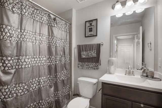 bathroom featuring vanity, curtained shower, and toilet