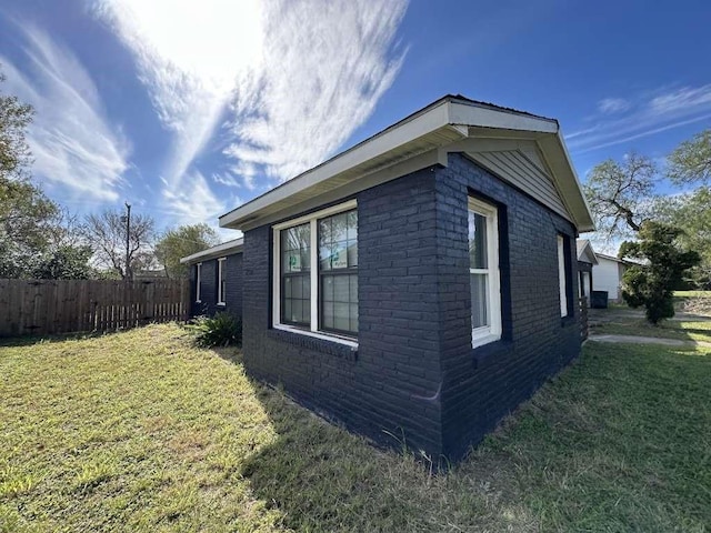 810 E Bowie Ave, Harlingen, TX 78550 - view of side of home featuring a lawn, brick siding, and fence