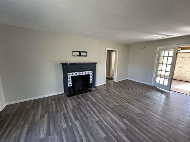 810 E Bowie Ave, Harlingen, TX 78550 - unfurnished living room featuring a tiled fireplace, baseboards, and dark wood-style floors
