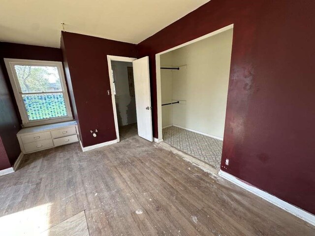810 E Bowie Ave, Harlingen, TX 78550 - unfurnished bedroom with baseboards, wood finished floors, and a closet