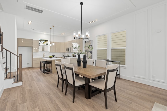 dining space featuring stairs, a chandelier, visible vents, and light wood-type flooring