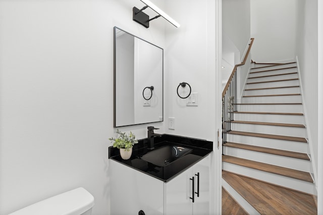 bathroom with vanity, wood finished floors, and toilet