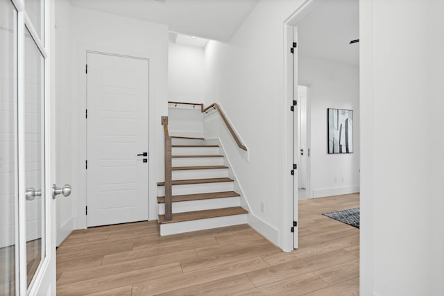 staircase featuring baseboards and wood finished floors