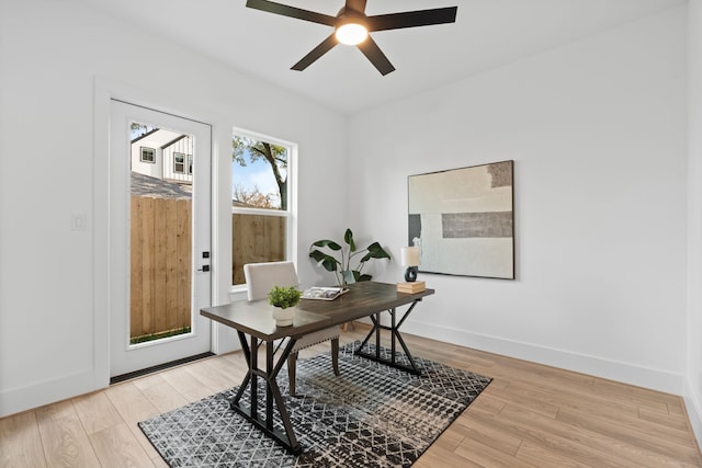 office area featuring light wood-style floors, baseboards, and ceiling fan