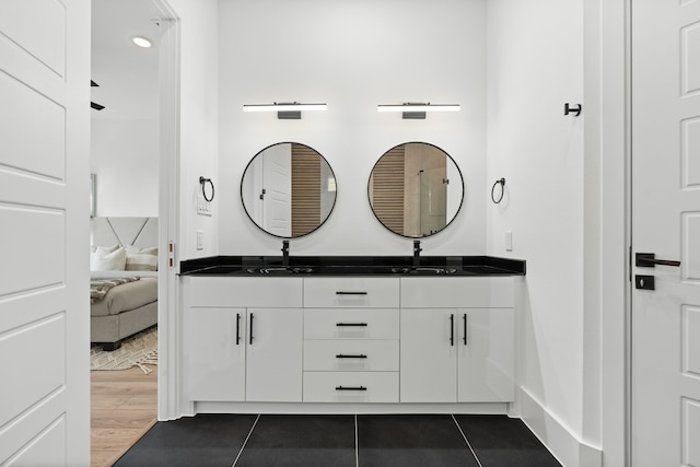 bathroom featuring double vanity, a sink, ensuite bathroom, and tile patterned flooring