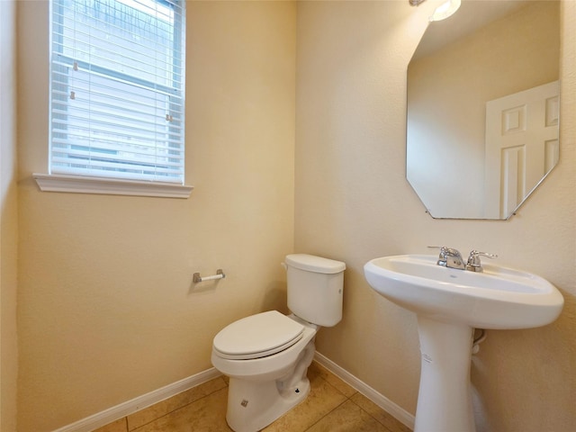 bathroom featuring toilet, tile patterned floors, and baseboards