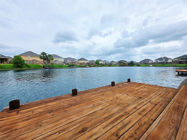 view of dock featuring a water view and a residential view