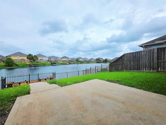view of patio featuring a residential view, fence, and a water view