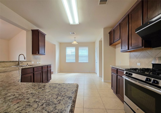 kitchen featuring backsplash, visible vents, stainless steel gas range oven, a sink, and under cabinet range hood