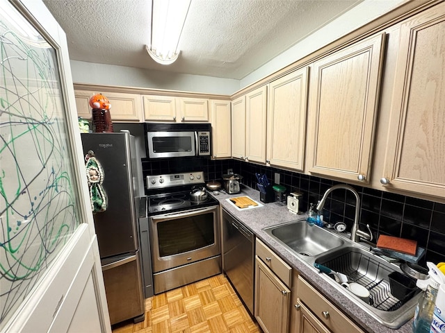 kitchen featuring a textured ceiling, appliances with stainless steel finishes, and tasteful backsplash