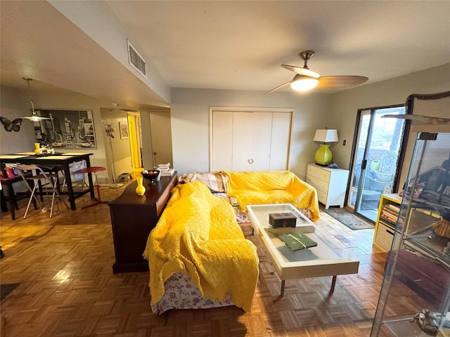 living area with visible vents and ceiling fan