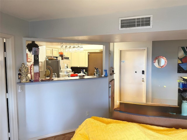 interior space with freestanding refrigerator and visible vents