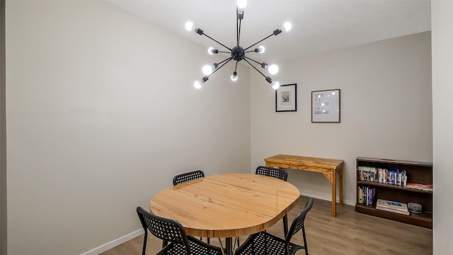 dining space featuring baseboards, a notable chandelier, and light wood-style flooring