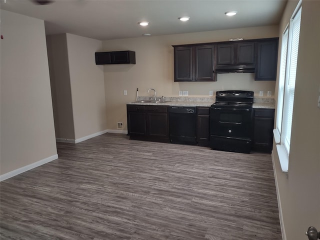 kitchen with baseboards, dark wood-type flooring, light countertops, a sink, and black appliances