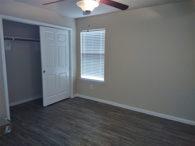 unfurnished bedroom featuring baseboards, ceiling fan, a closet, and dark wood finished floors