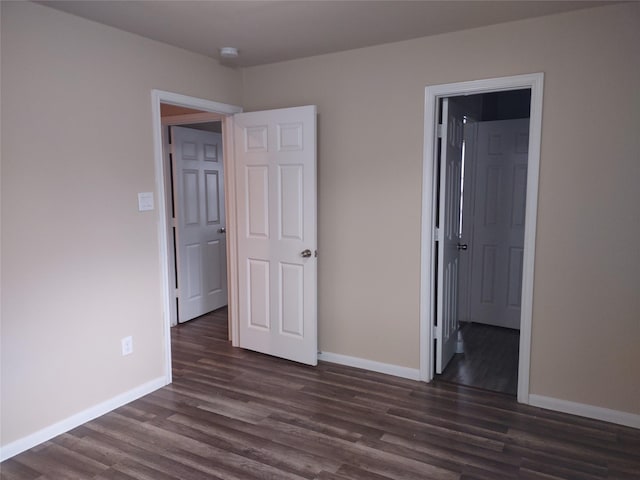 unfurnished bedroom featuring baseboards and dark wood finished floors