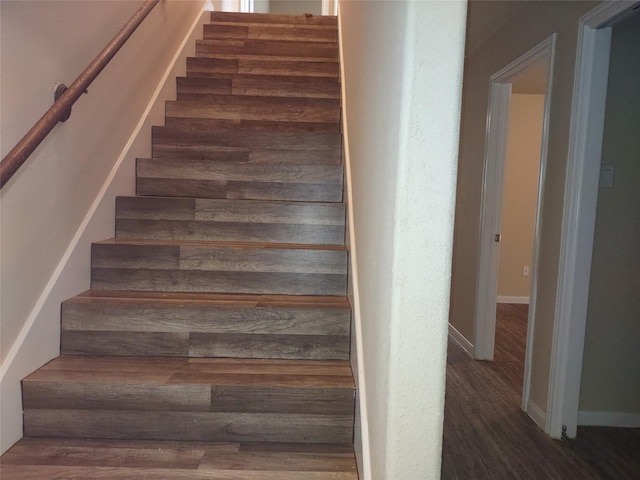 staircase with baseboards and wood finished floors
