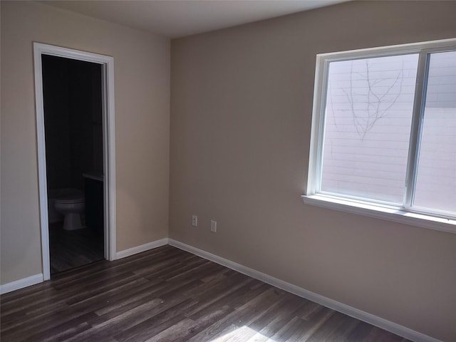 unfurnished bedroom featuring baseboards and dark wood finished floors