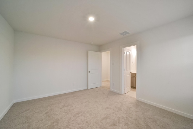 1642 Portia Ln, Conroe, TX 77301 - unfurnished bedroom with baseboards, light colored carpet, ensuite bath, and visible vents