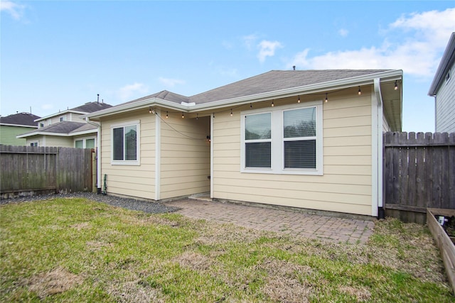 back of house with a lawn, a fenced backyard, and a patio