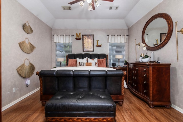 bedroom with vaulted ceiling, visible vents, and wood finished floors