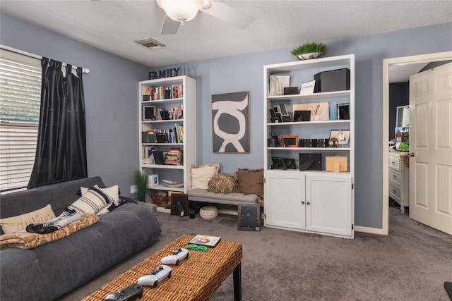 living area featuring a textured ceiling, visible vents, ceiling fan, and carpet floors