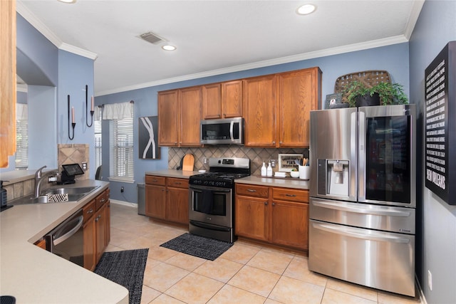 kitchen with visible vents, a sink, backsplash, brown cabinets, and appliances with stainless steel finishes