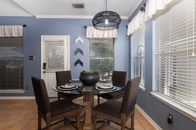 dining room with light tile patterned floors, crown molding, visible vents, and baseboards