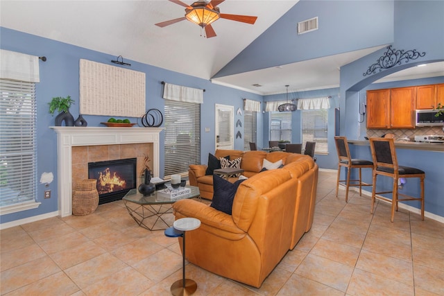 living area featuring light tile patterned floors, ceiling fan, baseboards, and visible vents